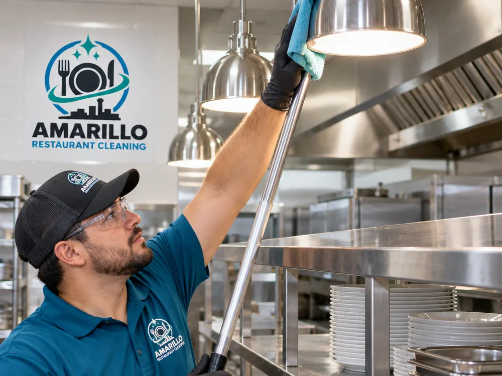 Clean overhead light fixtures and top edges of stainless shelving in a commercial kitchen